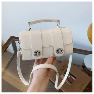 Detail of cream faux crocodile texture bag with silver twist locks and top handle