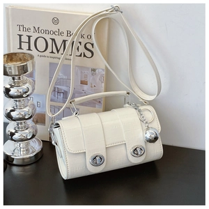 Macro detail of white crocodile-embossed leather mini bag with silver metal twist locks