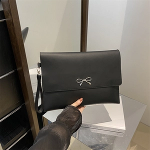 Minimalist black leather envelope clutch bag with silver metal bow and wrist strap