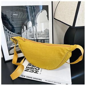 Dettaglio borsa a mezzaluna in nylon giallo senape con tracolla in tessuto regolabile