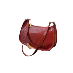Glossy red patent leather baguette bag with sleek minimalist shape and golden hardware