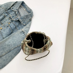 Top view of a brown and green plaid tweed bucket bag with a gold-tone chain strap