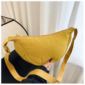 Dettaglio borsa a mezzaluna in nylon giallo acceso con zip e tracolla intrecciata