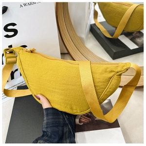 Dettaglio borsa a mezzaluna in nylon giallo con trama a pieghe e tracolla