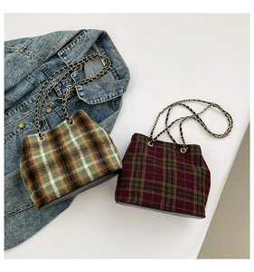 Top view of plaid wool bucket bags with chain straps on denim background decor