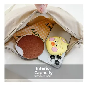 Primo piano della borsa in tela beige che mostra l'ampio interno con oggetti quotidiani