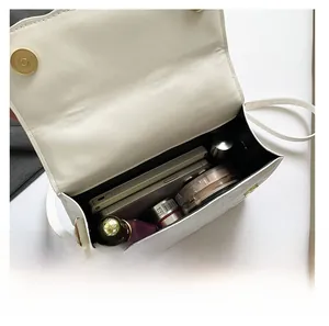 Top view of white crossbody bag interior showing spacious capacity for phone and cosmetics