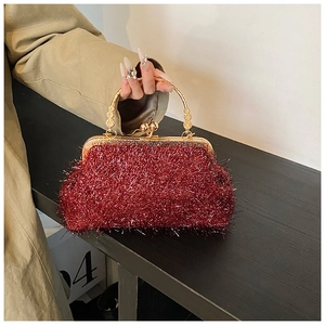 Detail of red tassel evening bag featuring retro gold floral clasp and sequin texture