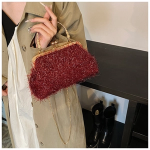 Détail du sac en peluche bordeaux avec monture dorée et bandoulière en chaîne