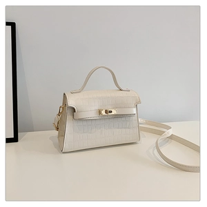 Close-up of crocodile texture faux leather bag with elegant gold twist lock and handle