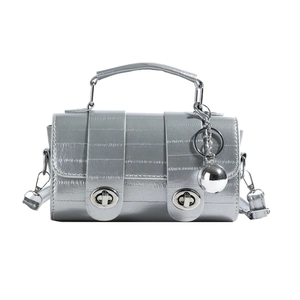 Silver crocodile texture handbag with metallic ball charm and top handle on white background