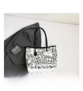 Detail view of a white graffiti tote bag with black illustrations and cloud charm