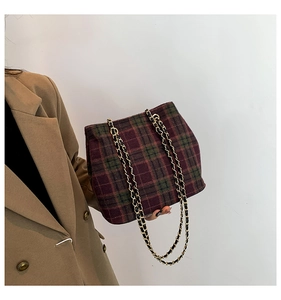 Detail of vintage plaid shoulder bag with gold chain strap on camel blazer