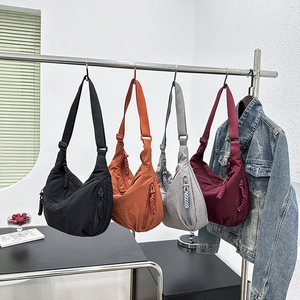 Detail of crescent moon nylon crossbody bags in four colors with adjustable straps