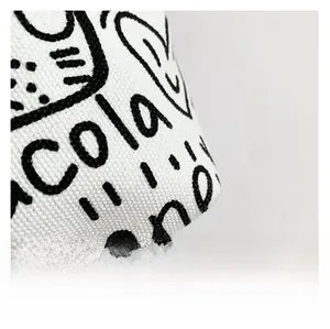 Close-up of white canvas tote bag with black graffiti art and heart-shaped print