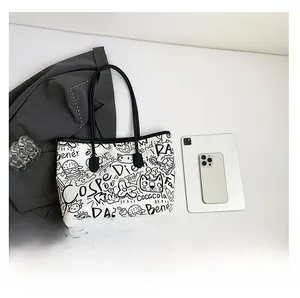 Flat lay of white graffiti tote bag with modern office accessories on grey suit background