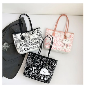 Detailed overhead view of graffiti tote bags with cloud charms and artistic prints