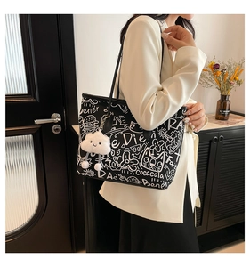 Chic graffiti tote bag detail with cartoon art and cloud charm on a stylish model