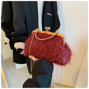 Detail of burgundy plush faux fur handbag with golden handle and chain shoulder strap