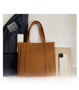 Brown faux leather tote bag detail with exterior pocket and spacious interior compartment