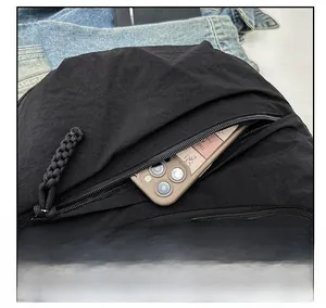 Detail of exterior zipper pocket on black crescent bag showing phone storage capacity