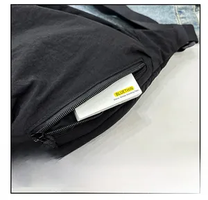 Close-up of black nylon crescent bag side pocket with metal zipper and makeup palette