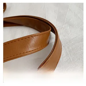 Close-up of brown PU leather shoulder strap showing fine stitching and grain texture