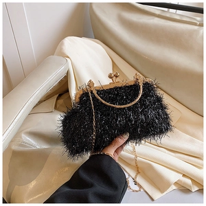 Detail of black faux fur evening bag featuring gold metal frame and spherical clasps