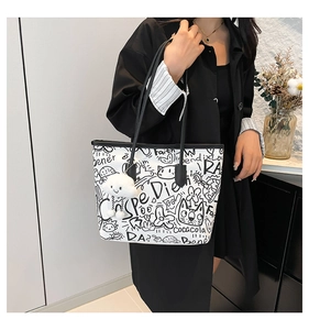 Detail of white graffiti tote bag featuring plush cloud charm and hand-drawn art patterns