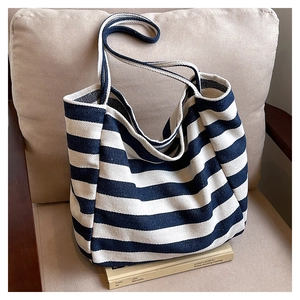 Detailed close-up of blue and white striped canvas tote bag on a neutral background
