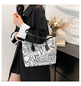 Detail shot of white graffiti tote bag showing artistic prints and black shoulder straps
