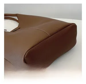 Close-up of caramel brown tote bag showing the high-quality lychee grain leather texture