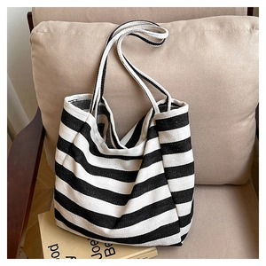 Macro view of the black and white striped canvas tote bag on a cozy fabric chair