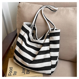 Detail view of durable canvas texture and classic black and white stripes on the tote bag
