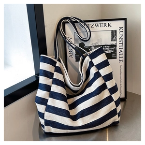 Detail of blue and white striped canvas tote bag with reinforced handles and large capacity