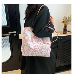 Detail of white tote bag featuring pink graffiti patterns and stylish handle design