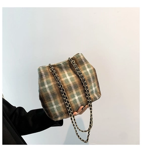 Detail of green plaid plush tote bag with gold chain strap and textured fabric