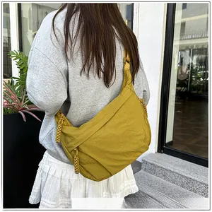 Detail of mustard yellow nylon crescent bag with textured fabric and knotted zipper pull