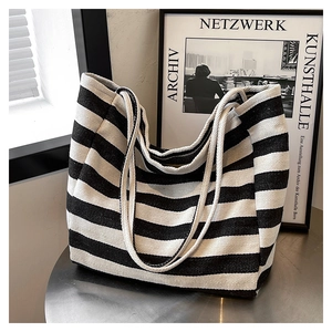 Detail of striped canvas tote bag with thick texture and dual strap design