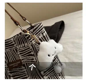 Detailed close-up of woven canvas texture with leather strap and cloud charm pendant