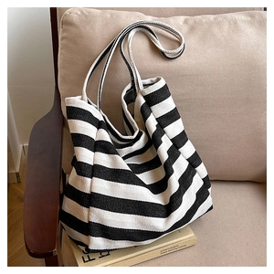Detailed texture of a black and white striped canvas tote bag on a cozy armchair