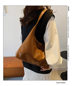 Close-up of a brown PU leather shoulder bag with a textured finish and wide strap detail