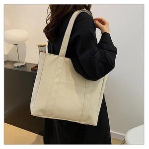 Detail view of large cream tote bag showing wrinkled leather texture and side pocket