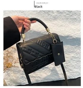 Detail of black quilted leather crossbody bag with FASHION embossed texture and mini pouch