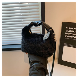 Detail of black plush handbag featuring faux rabbit fur texture and twisted leather handle