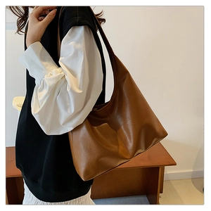 Detailed close-up showing the soft brown leather texture and stitching of the hobo bag