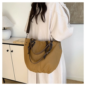 Detailed back view of a khaki canvas tote bag with adjustable brown shoulder straps
