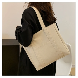 Minimalist beige oversized tote bag shown on model for size perspective and scale