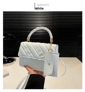 Close-up of white quilted handbag with woven handle, fashion logo, and mini pouch accessory