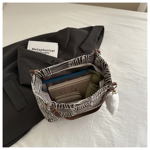 Large geometric canvas tote bag showing spacious interior with books and a small umbrella